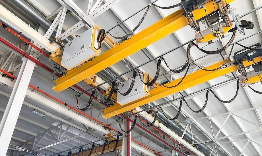 Dlaczego warto wybrać podwieszaną suwnicę pomostową do transportu ciężkich ładunków?