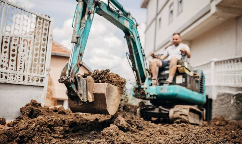 Jak dobrać koparkę do wykopu pod szambo przy ciasnym dojeździe i ciężkim gruncie