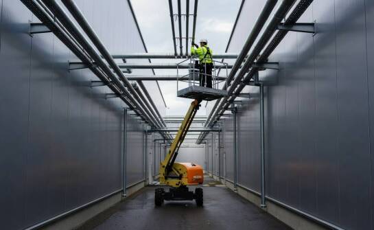 Jak teren przemysłowy i ciasne dojścia zmieniają dobór podnośnika przy halach produkcyjnych