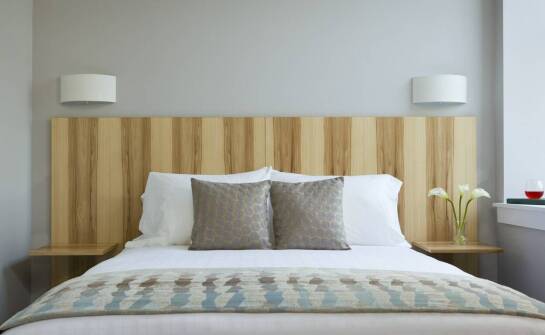 Łóżka drewniane z tapicerowanym zagłówkiem – inspiracje i zalety tego połączenia