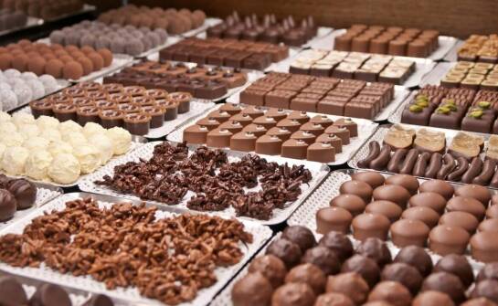 Dzięki czemu praliny zyskują idealną gładkość, połysk i odporność na topnienie w dłoniach?