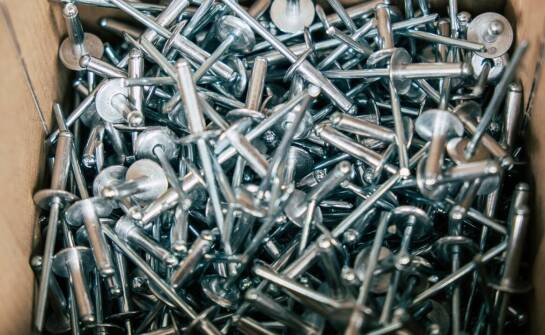 Jakie są kluczowe zalety stosowania sworzni i nitów w branży budowlanej?