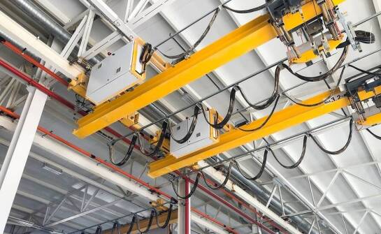 Dlaczego warto wybrać podwieszaną suwnicę pomostową do transportu ciężkich ładunków?