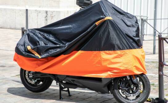 Motocykl z kuframi pod przykryciem — jak warunki postoju zmieniają wybór osłony