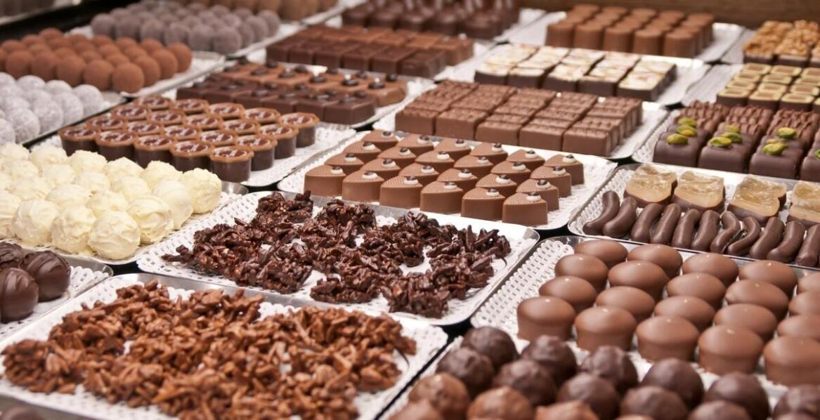 Dzięki czemu praliny zyskują idealną gładkość, połysk i odporność na topnienie w dłoniach?